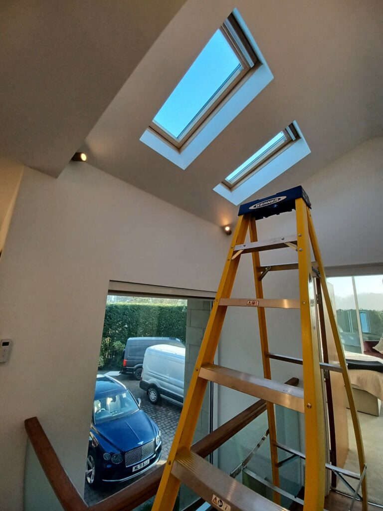 velux window being installed with a yellow ladder in forefront